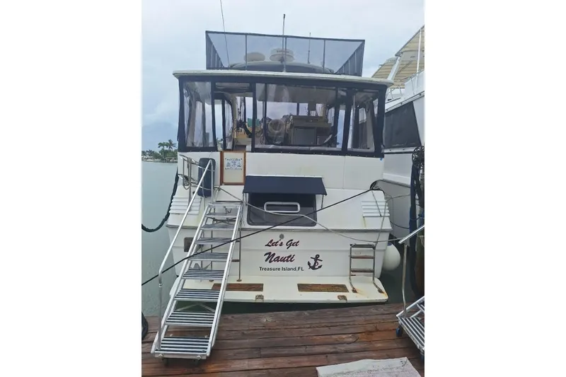 Slide: The Image of 1986 Sea Ray 410 Aft Cabin yacht docked, featuring rear view and boarding steps. - 18