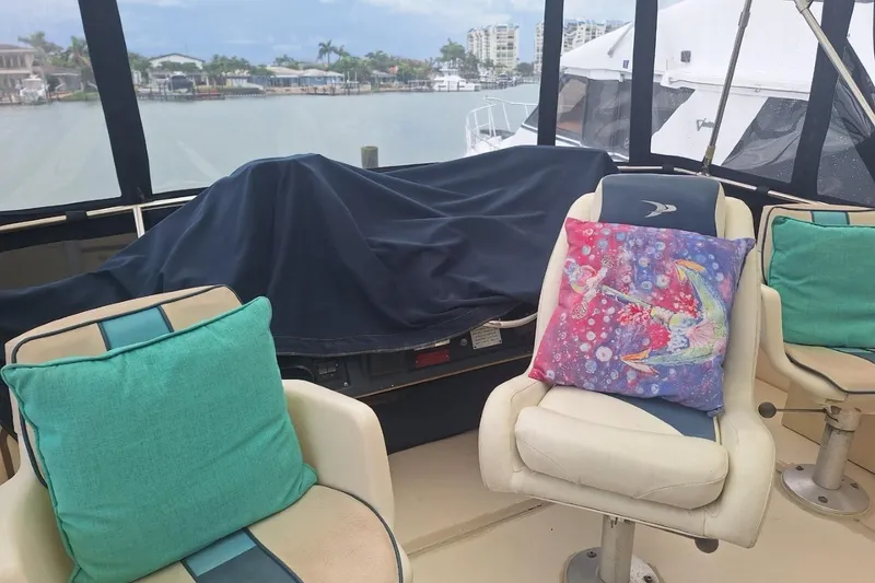 Slide: The Image of 1986 Sea Ray 410 Aft Cabin interior with colorful cushions and marina view. - 20