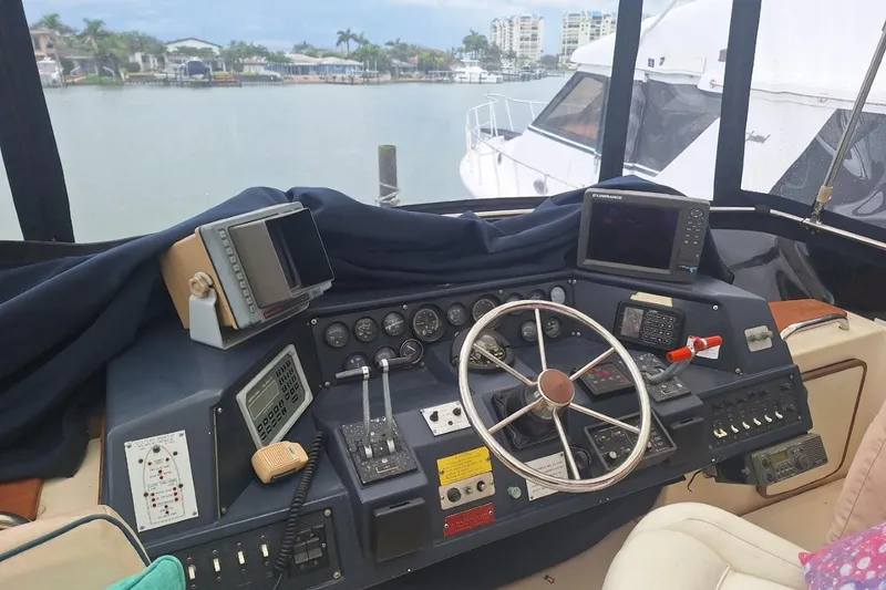 Slide: The Image of 1986 Sea Ray 410 Aft Cabin helm with steering wheel, gauges, and navigation equipment. - 21