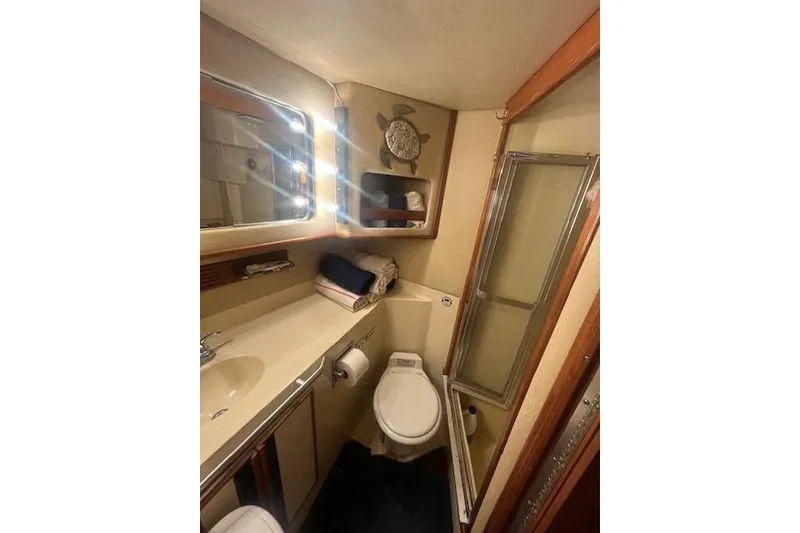 Slide: The Image of 1986 Sea Ray 410 Aft Cabin bathroom with shower, sink, and toilet. - 24
