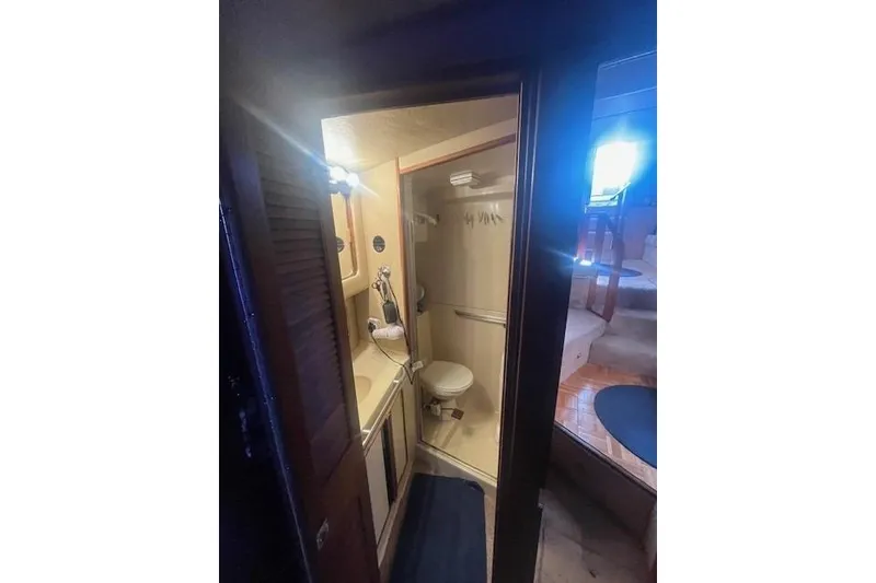 Slide: The Image of 1986 Sea Ray 410 Aft Cabin bathroom with shower, sink, and toilet. - 26