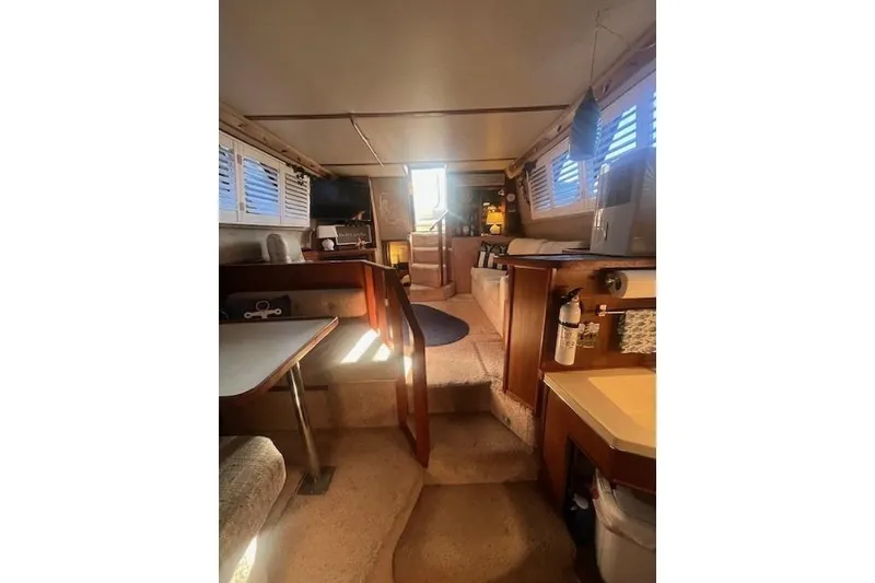 Slide: The Image of Interior of 1986 Sea Ray 410 Aft Cabin with cozy seating and natural light. - 27
