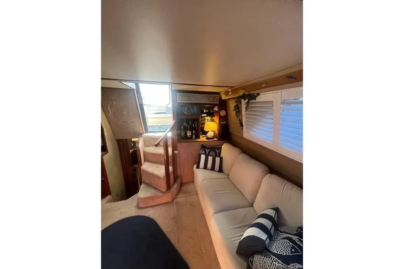 Slide: The Image of Interior of 1986 Sea Ray 410 Aft Cabin with cozy seating and decor. - 28