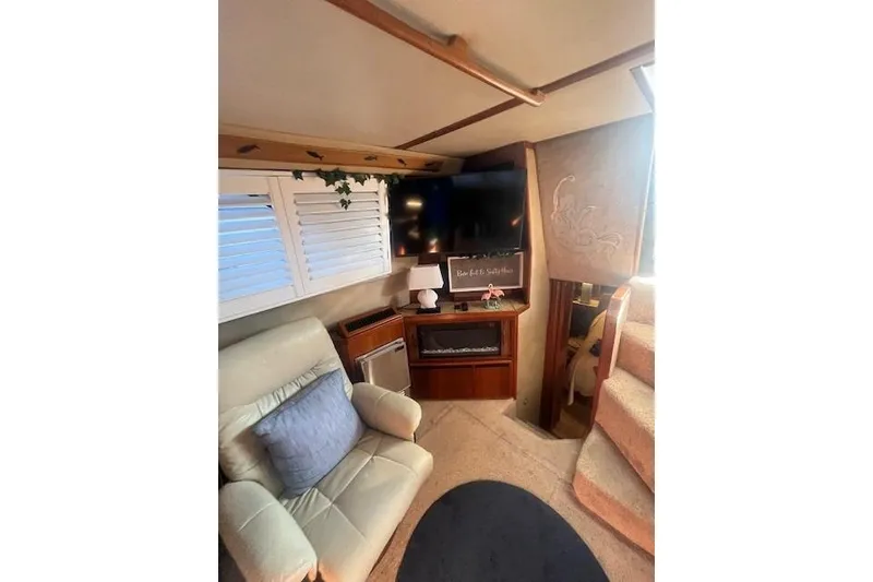 Slide: The Image of Interior of 1986 Sea Ray 410 Aft Cabin with cozy seating and entertainment area. - 29