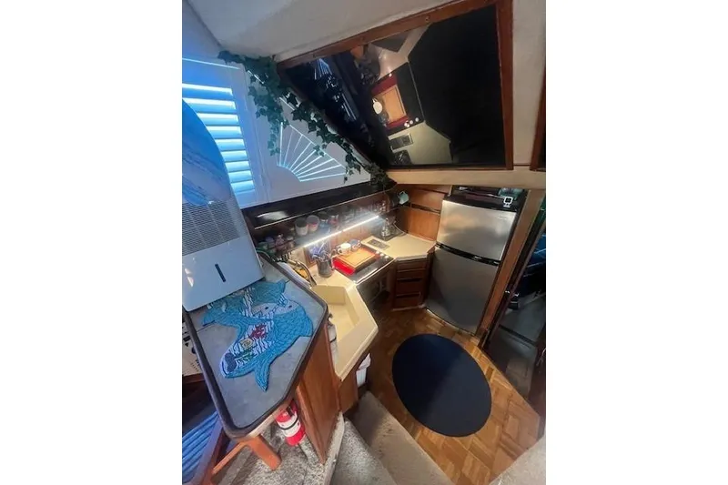 Slide: The Image of 1986 Sea Ray 410 Aft Cabin kitchen with modern appliances and cozy design. - 32