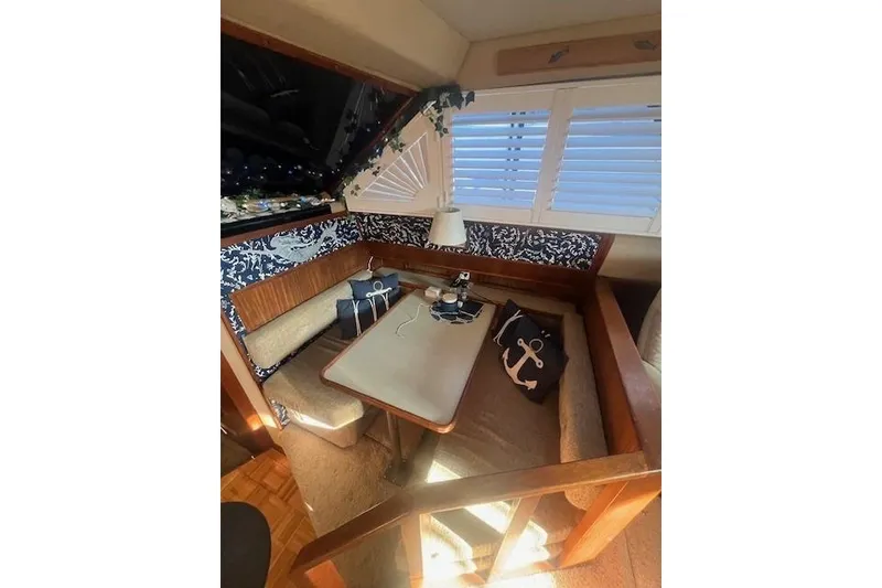 Slide: The Image of 1986 Sea Ray 410 Aft Cabin interior with cozy dining area and nautical decor. - 33