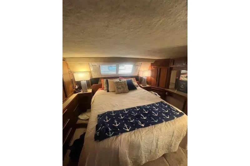 Slide: The Image of Cozy bedroom in 1986 Sea Ray 410 Aft Cabin with nautical decor and ambient lighting. - 35