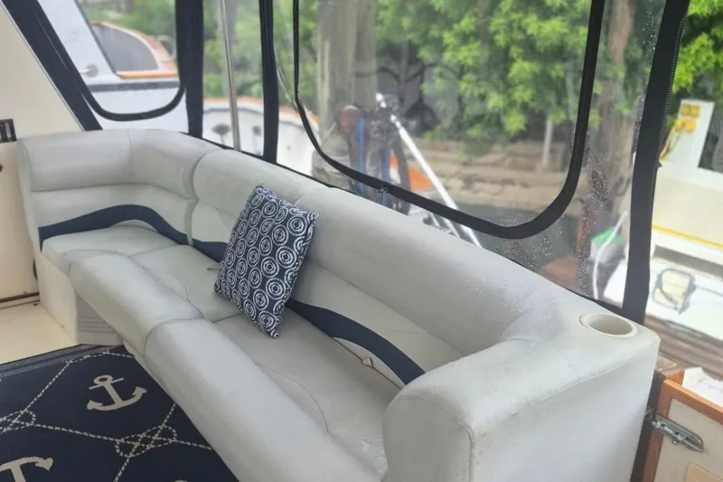 Slide: The Image of 1986 Sea Ray 410 Aft Cabin interior with white seating and nautical-themed decor. - 4