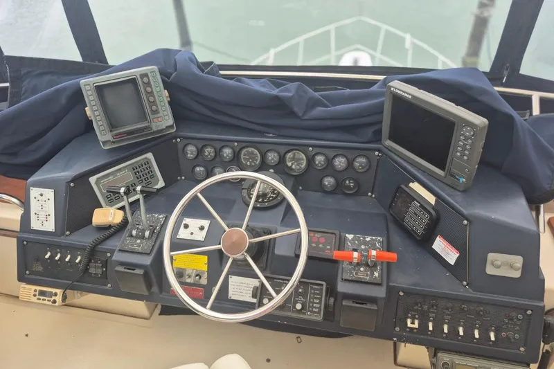 Slide: The Image of 1986 Sea Ray 410 Aft Cabin helm with navigation instruments and steering wheel. - 6