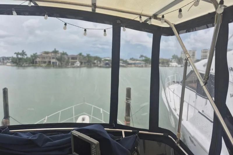 Slide: The Image of 1986 Sea Ray 410 Aft Cabin yacht with marina view through covered deck. - 7