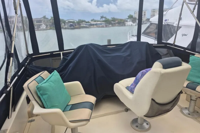 Slide: The Image of 1986 Sea Ray 410 Aft Cabin interior with cushioned seating and marina view. - 9