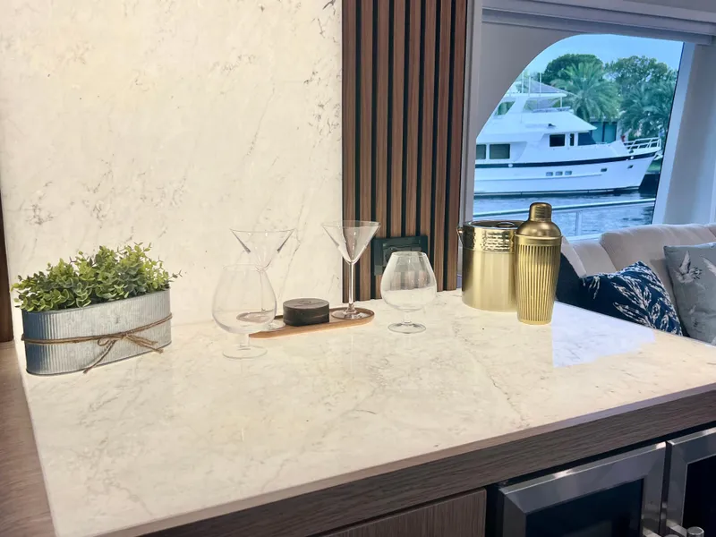 Slide: The Image of Luxurious yacht interior with marble countertop, glassware, and a view of a boat outside. - 46