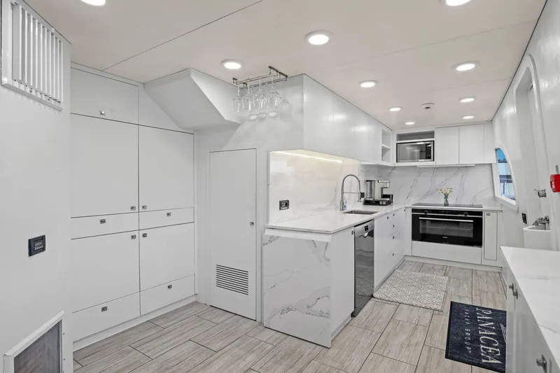 Slide: The Image of Modern kitchen interior on 2011 Mengi Yay 115 MY yacht, featuring sleek white cabinetry and appliances. - 47