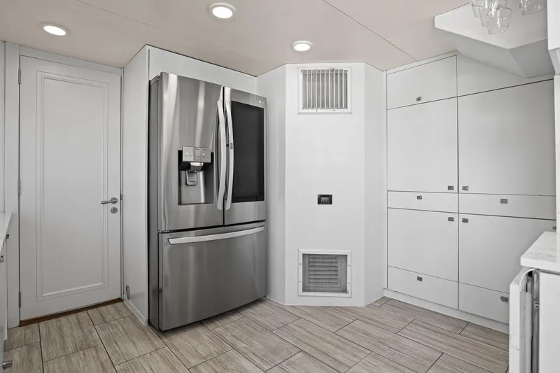 Slide: The Image of Modern kitchen with stainless steel refrigerator, white cabinetry, and tiled flooring on Mengi Yay 115 MY yacht. - 49