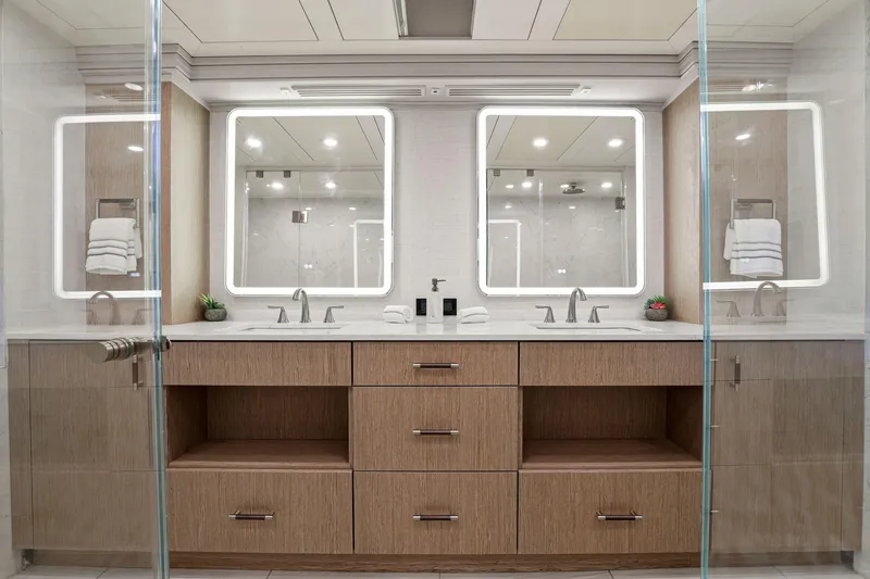 Slide: The Image of Luxurious yacht bathroom with dual sinks, illuminated mirrors, and modern wood cabinetry on Mengi Yay 115 MY. - 55