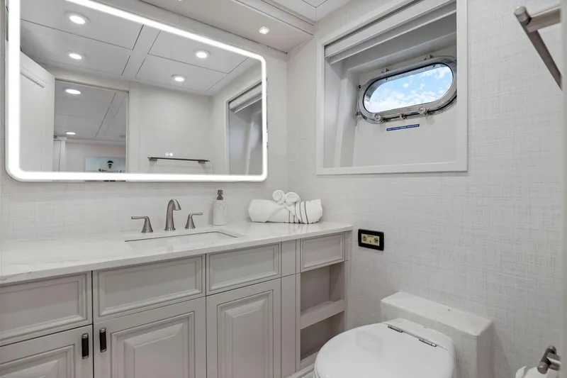Slide: The Image of Luxurious yacht bathroom with modern fixtures, illuminated mirror, and porthole window on Mengi Yay 115 MY. - 81
