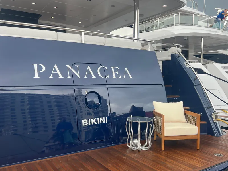 Slide: The Image of Luxury yacht "Panacea" docked, featuring elegant seating on its wooden deck. - 84