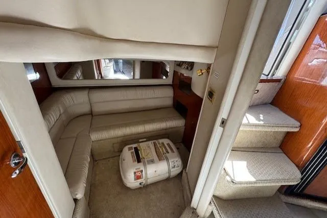 Slide: The Image of 2000 Sea Ray 410 Express Cruiser interior with beige seating and stairs. - 10