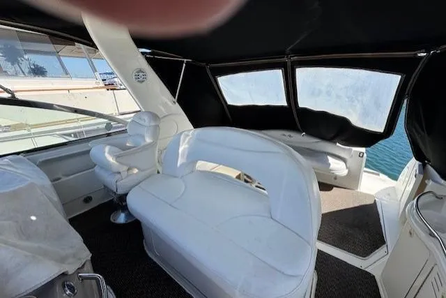 Slide: The Image of 2000 Sea Ray 410 Express Cruiser interior with white seating and black canopy. - 13
