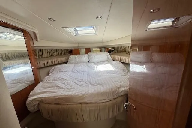 Slide: The Image of Luxurious cabin interior of 2000 Sea Ray 410 Express Cruiser with cozy bedding. - 2