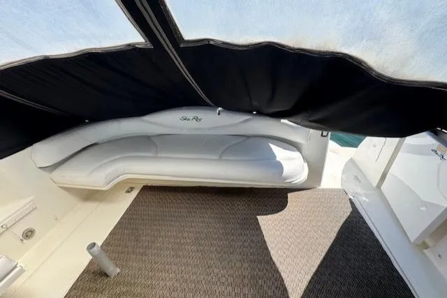 Slide: The Image of 2000 Sea Ray 410 Express Cruiser interior with white seating and black canopy. - 21