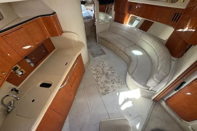 Slide: The Image of Interior of 2000 Sea Ray 410 Express Cruiser with curved seating and wooden cabinetry. - 3