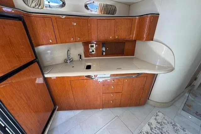 Slide: The Image of 2000 Sea Ray 410 Express Cruiser kitchen with wood cabinetry and modern appliances. - 4