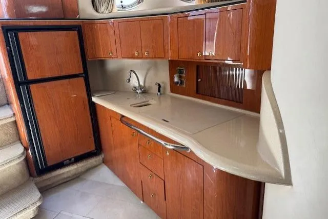 Slide: The Image of 2000 Sea Ray 410 Express Cruiser kitchen with wood cabinets and modern appliances. - 5