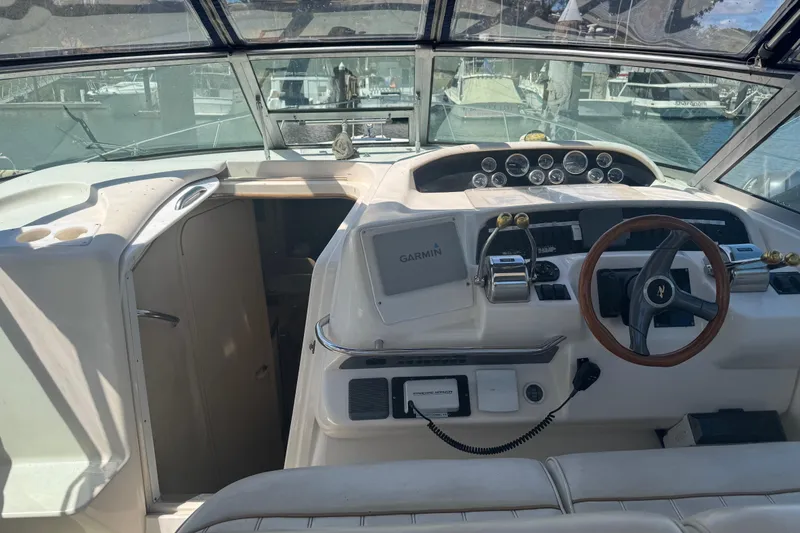Slide: The Image of 1998 Sea Ray 330 Sundancer cockpit with Garmin navigation and wooden steering wheel. - 11