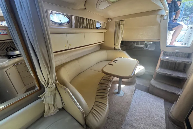 Slide: The Image of 1998 Sea Ray 330 Sundancer interior with beige seating, table, and stairs. - 17