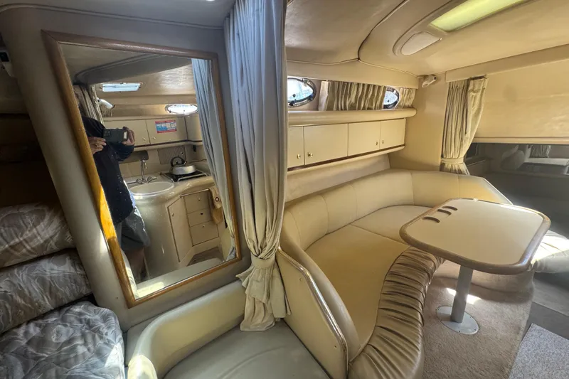 Slide: The Image of 1998 Sea Ray 330 Sundancer cabin interior with seating, table, and kitchenette. - 18