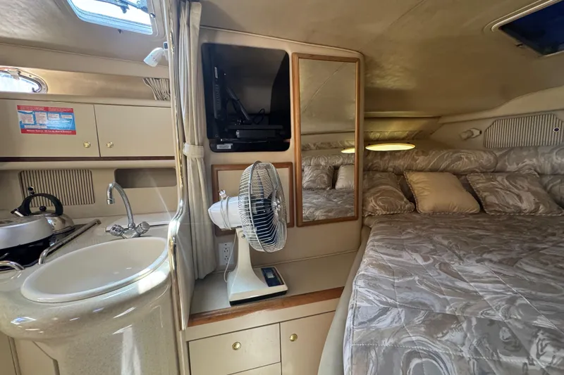 Slide: The Image of 1998 Sea Ray 330 Sundancer cabin interior with bed, sink, and fan. - 20