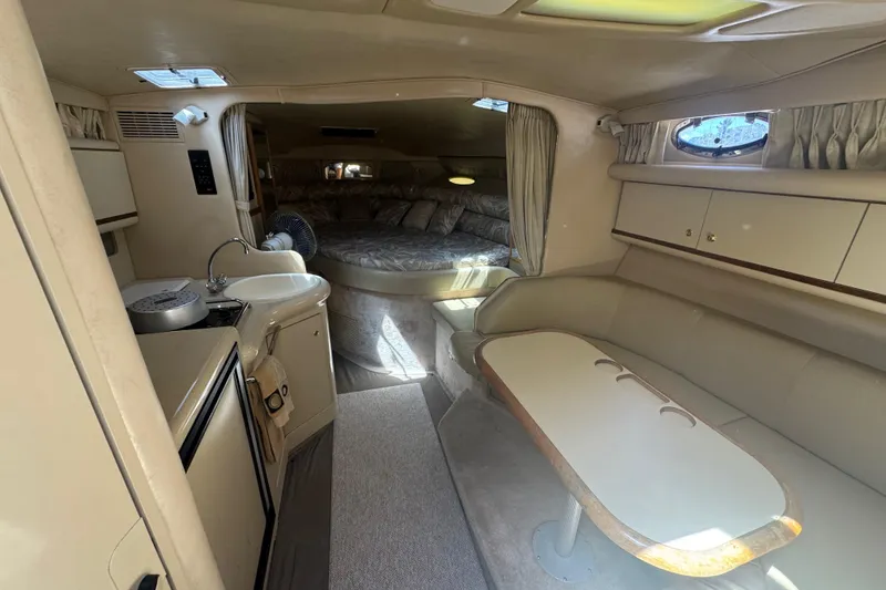 Slide: The Image of 1998 Sea Ray 330 Sundancer interior with kitchenette, seating, and sleeping area. - 22