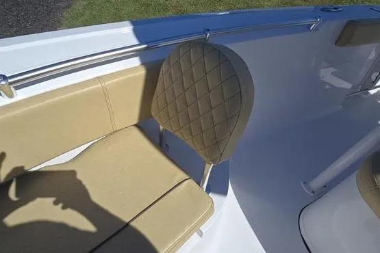 Slide: The Image of 2023 Sportsman Open 242 Center Console boat interior with beige seating and stainless steel railing. - 9