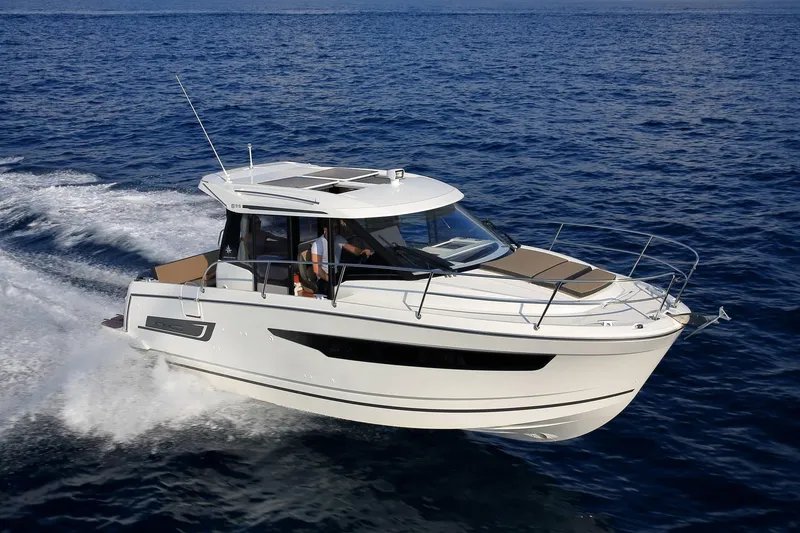 Slide: The Image of 2019 Jeanneau 895NC motorboat cruising on open water. - 0