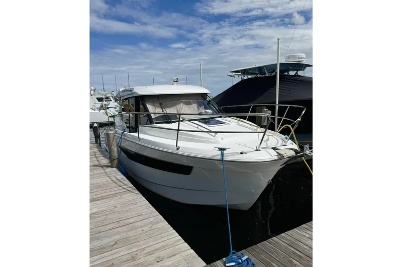Slide: The Image of 2019 Jeanneau 895NC boat docked at marina under blue sky. - 1