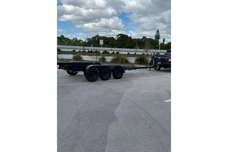 Slide: The Image of Trailer for Jeanneau 895NC 2019 boat, parked in a lot with cloudy sky. - 16