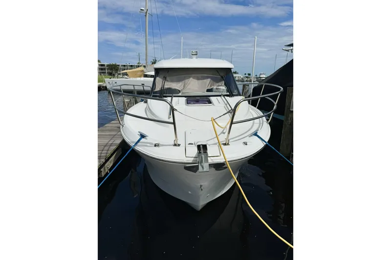 Slide: The Image of 2019 Jeanneau 895NC boat docked at marina under clear blue sky. - 2