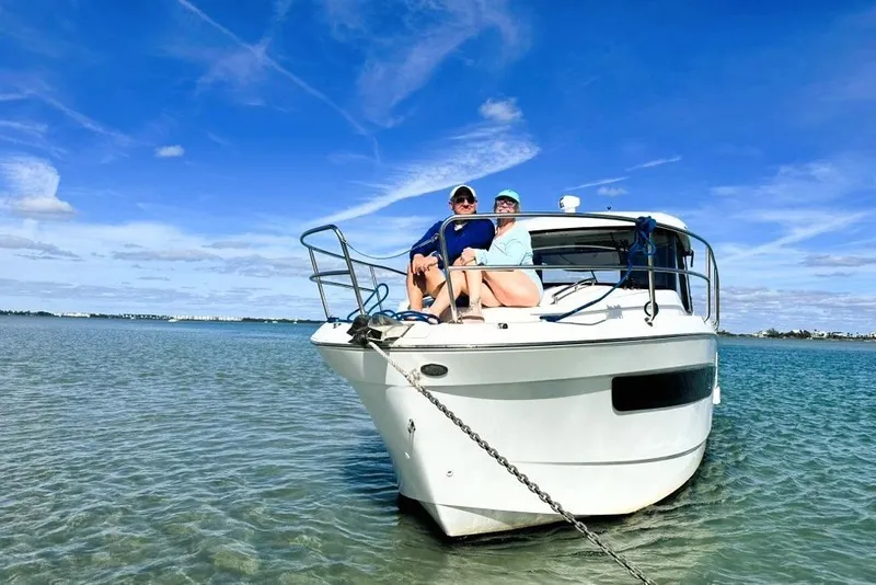 Slide: The Image of 2019 Jeanneau 895NC boat with two people relaxing on deck in sunny waters. - 3