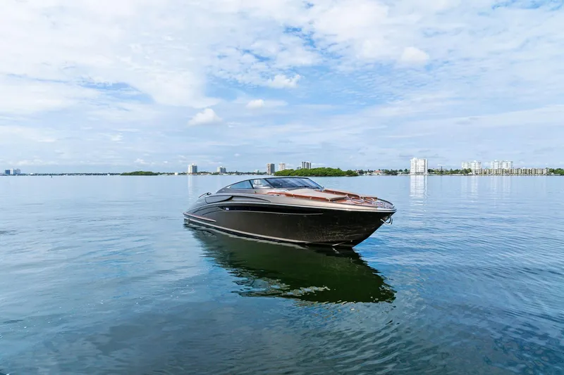 Slide: The Image of 2014 Riva Rivarama luxury yacht on calm water with city skyline background. - 2