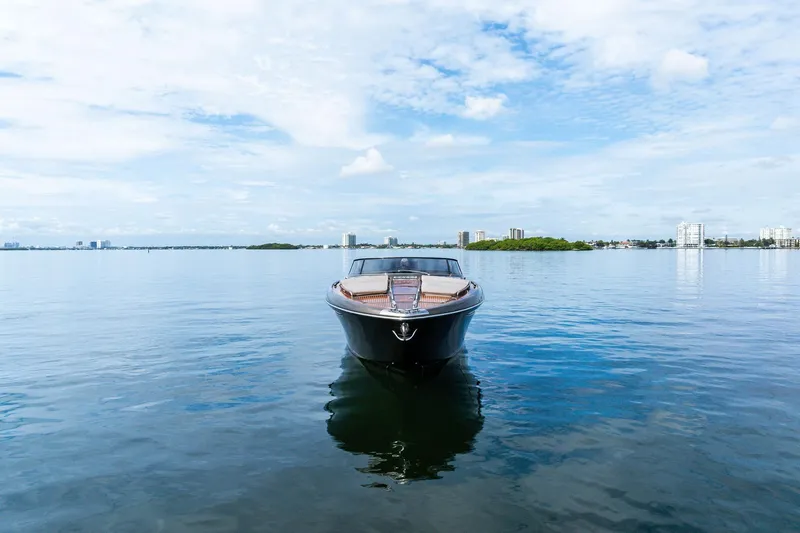 Slide: The Image of 2014 Riva Rivarama luxury yacht on calm water with city skyline backdrop. - 3