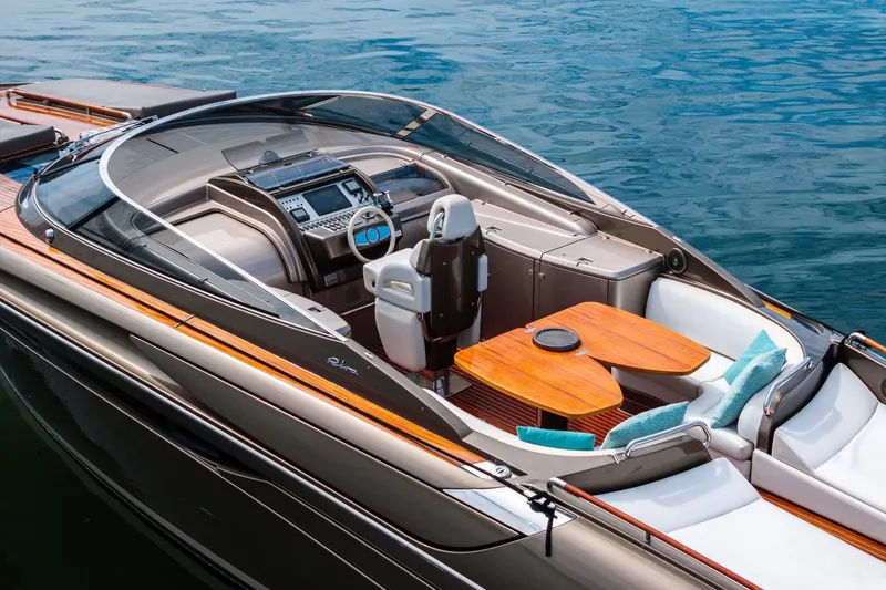 Slide: The Image of Luxurious 2014 Riva Rivarama yacht with elegant seating and modern dashboard on calm water. - 7