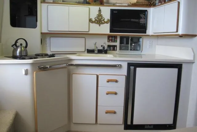 Slide: The Image of Compact kitchen in a 1992 Sea Ray 370 Express Cruiser with modern appliances and storage. - 13