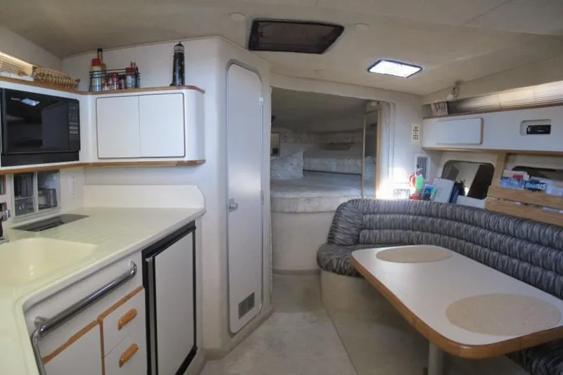 Slide: The Image of Interior of 1992 Sea Ray 370 Express Cruiser with kitchenette and dining area. - 19