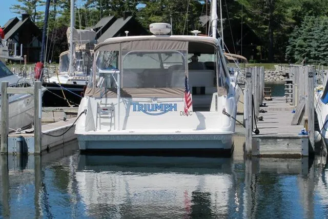 Slide: The Image of 1992 Sea Ray 370 Express Cruiser docked at marina, rear view with American flag. - 5