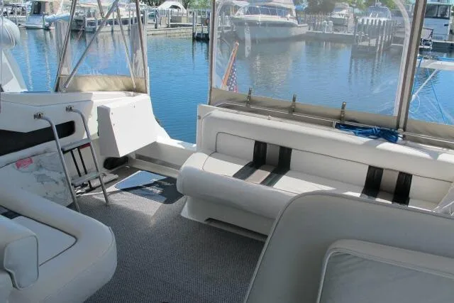 Slide: The Image of 1992 Sea Ray 370 Express Cruiser interior with seating, docked at marina. - 7