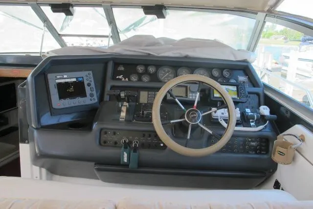 Slide: The Image of 1992 Sea Ray 370 Express Cruiser helm with steering wheel and navigation instruments. - 9