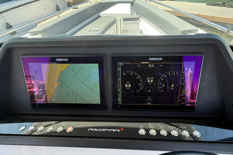 Slide: The Image of 2021 Axopar 28 WetBar dashboard with navigation screens, docked at marina. - 10