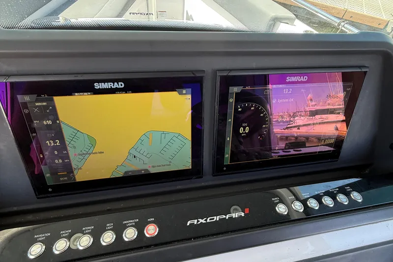 Slide: The Image of 2021 Axopar 28 WetBar boat cockpit with steering wheel and navigation system. - 15