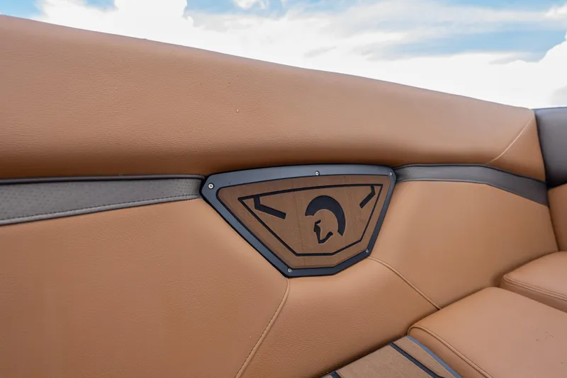 Slide: The Image of 2025 Centurion Nv233 boat interior with tan leather seating and stylish emblem. - 14